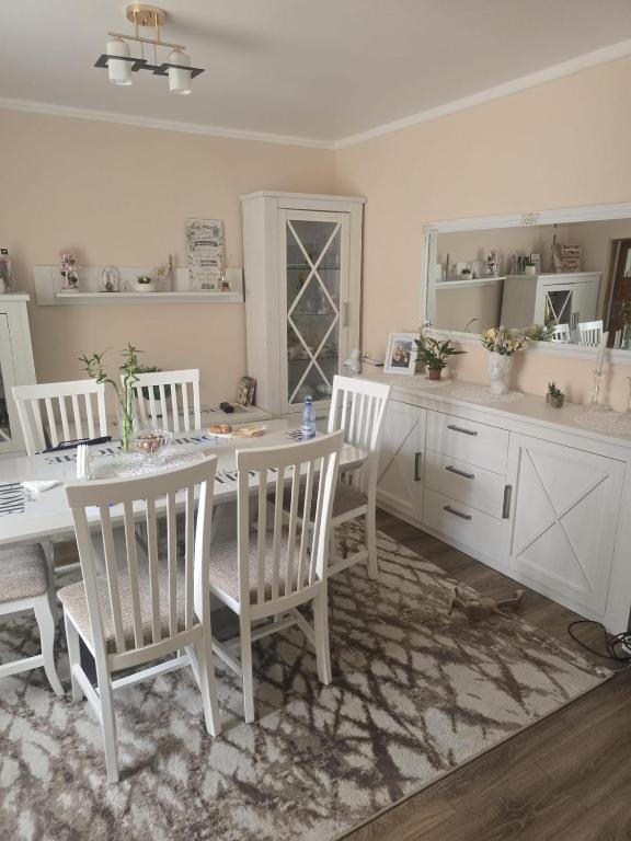 a white dining room with a table and chairs at Casa Izabella in Tîrnăveni