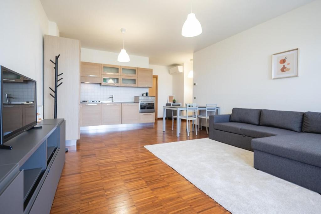 a living room with a couch and a kitchen at Angelic Darsena Apartment in Ravenna