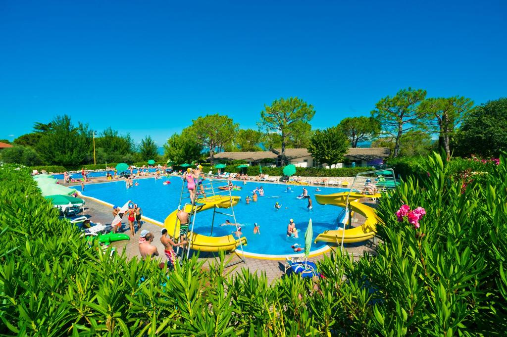 un grupo de personas en una piscina en un complejo en Happy Camp Mobile Homes in Camping Cisano San Vito, en Bardolino