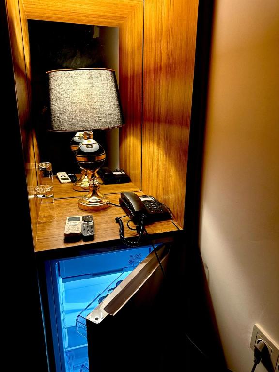 a desk with a phone and a lamp on it at Starmax City's Hotel YALOVA in Kâzımiye