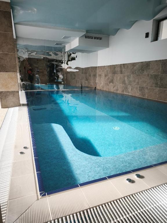 a large swimming pool with blue water in a building at Smida Park Mountain Retreat & SPA in Smida