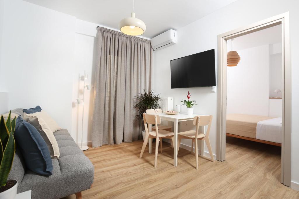 a living room with a table and a couch and a bedroom at Samà Housing in Larisa