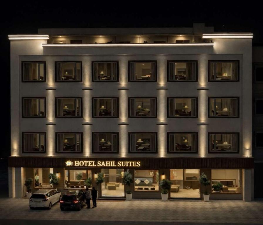 a hotel with two cars parked in front of it at Hotel Sahil Suites in Katra