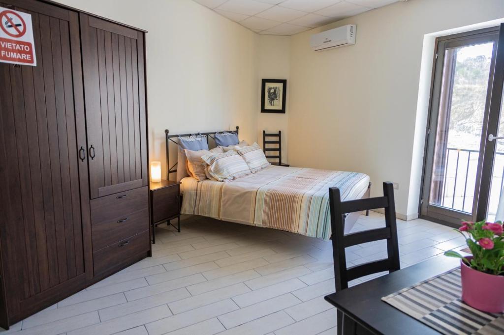 ein Schlafzimmer mit einem Bett, einer Kommode und einem Tisch in der Unterkunft White Room "Dimore Lucane" in Ruoti