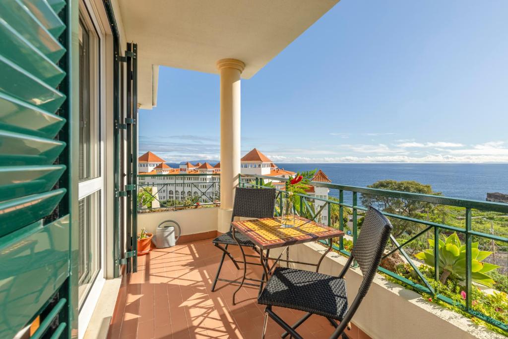 a balcony with a table and chairs and the ocean at BoLina Ocean View in Caniço