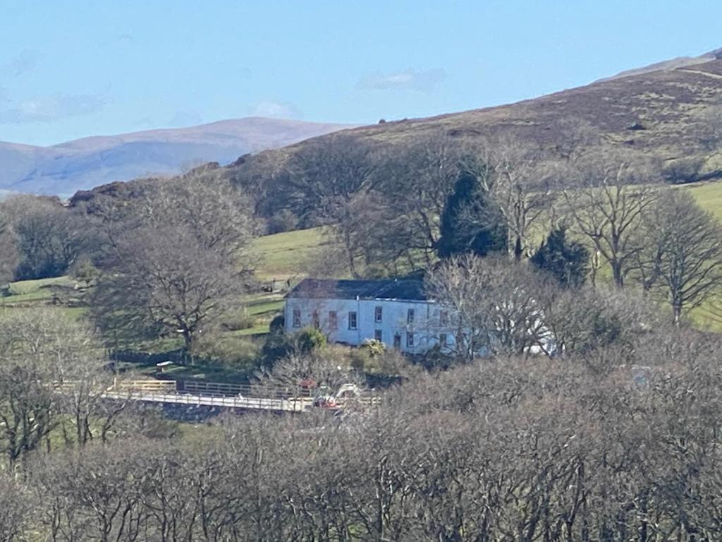 a house in the middle of a hill with trees at The Hideaway Embleton in Embleton