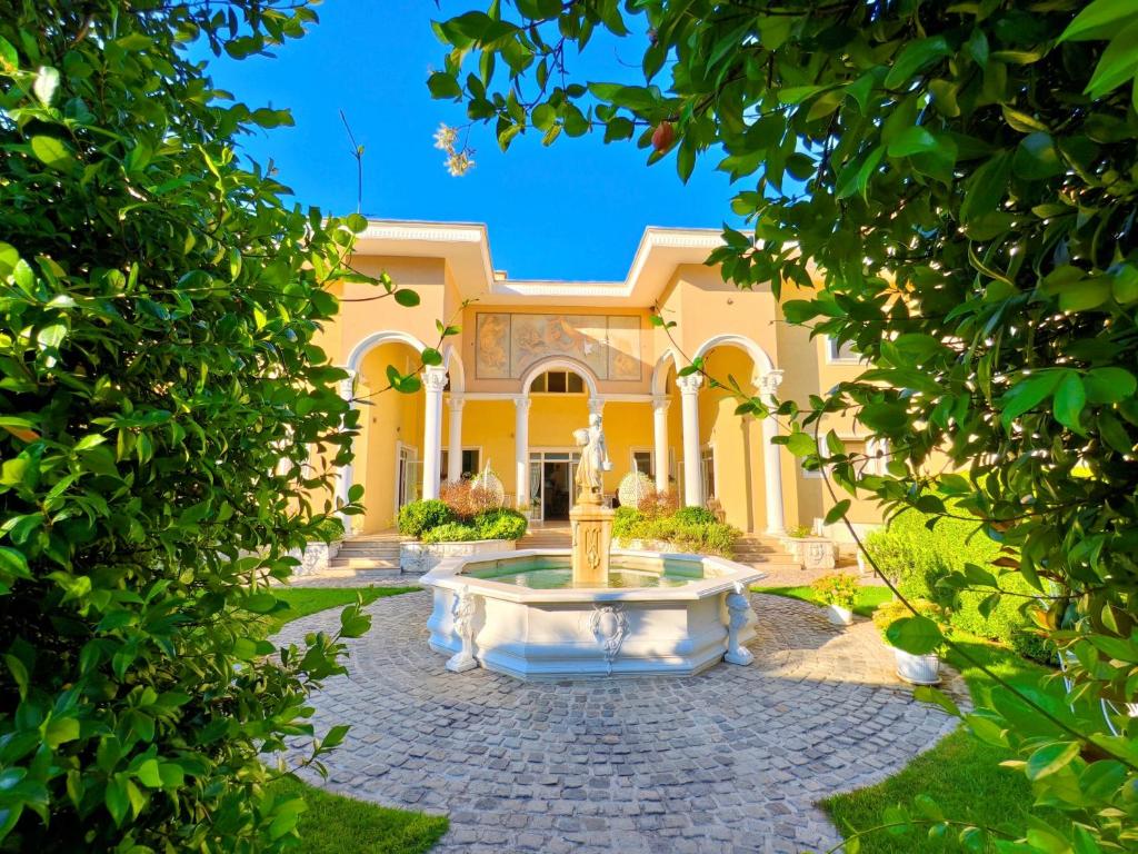 a house with a fountain in the middle of a yard at Бутиков хотел History in Haskovo