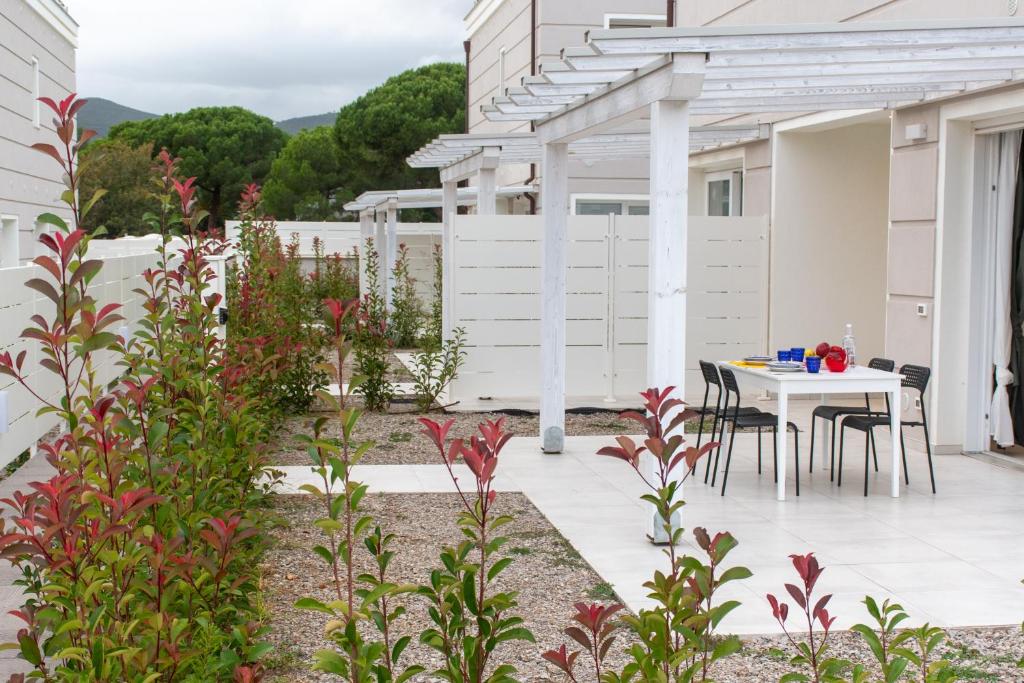 a patio with a white pergola and a table and chairs at Margidore Beach in Lacona