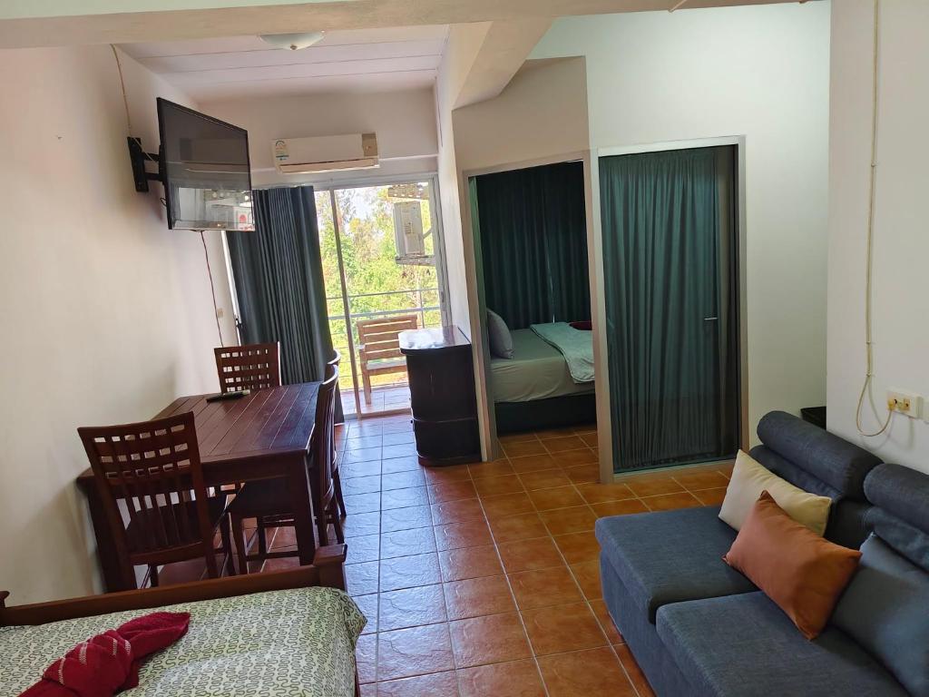 a living room with a couch and a table and a television at Avatara A Ocean Views by malai in Ban Tha Fat