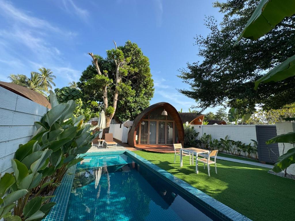 a backyard with a swimming pool and a house at Found Mansion Langkawi in Pantai Cenang