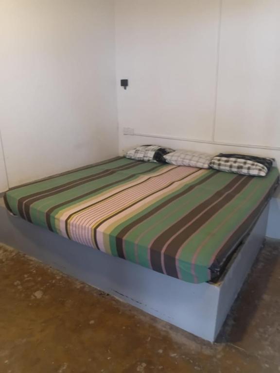 a bed with a striped comforter on top of it at Ocean beach in Galle