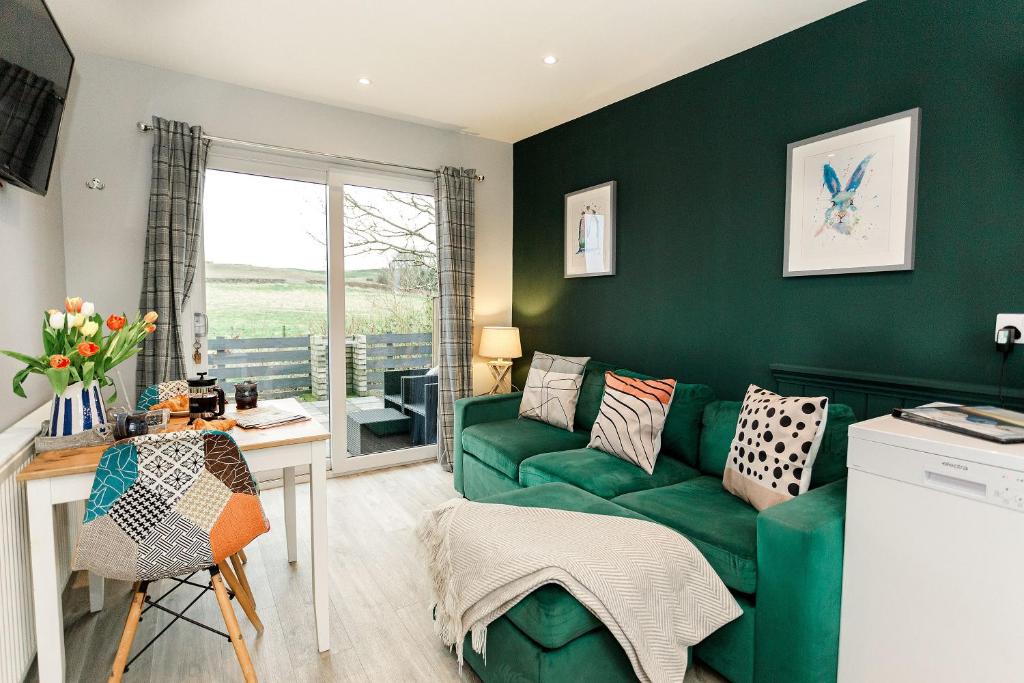 a green living room with a green couch at Beth's Bothy in Gatehouse of Fleet