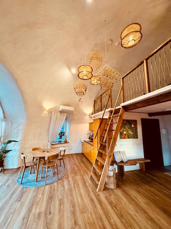 a living room with a table and a loft bed at Kupolinis namelis in Kilova II