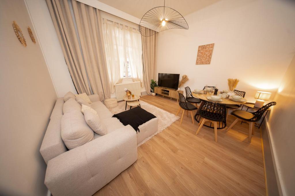 a living room with a white couch and a table at L'Élégance - Cozy & Parking in Chambéry