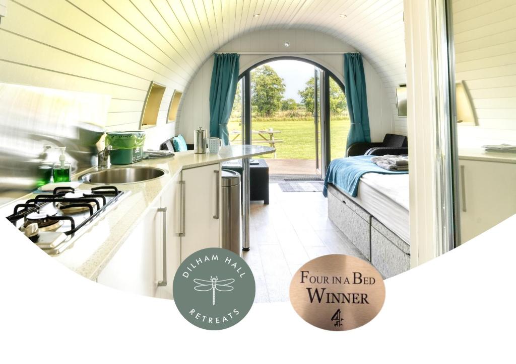 a kitchen with a stove and a bed in a room at Dilham Hall Retreats in Dilham