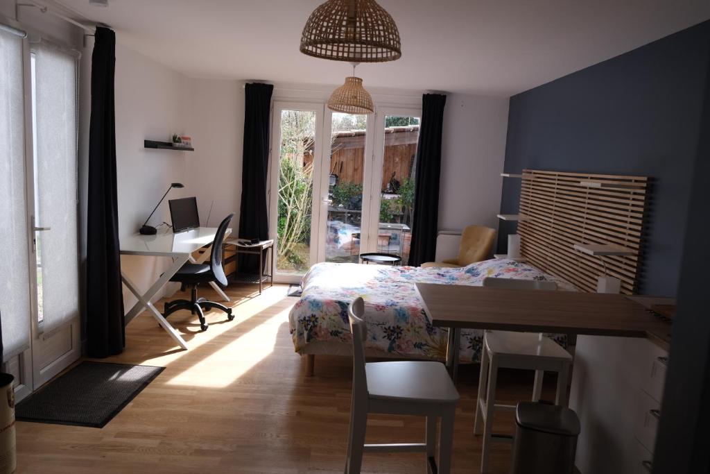 a bedroom with a bed and a desk and a table at Beau studio calme, indépendant avec terrasse in Pessac