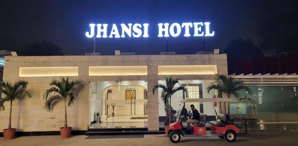 a man in a golf cart in front of ahmurst hotel at Jhansi Hotel in Jhānsi