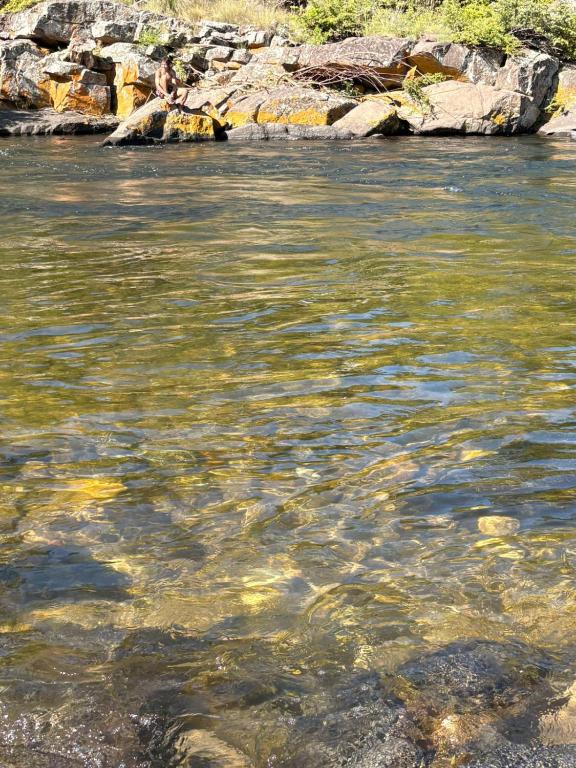 a body of water with rocks in the water at Playa Hostel in Santa Rosa de Calamuchita