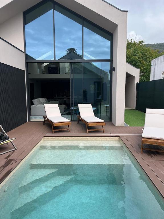 a swimming pool with two chairs and a house at Fine Arts in Moledo