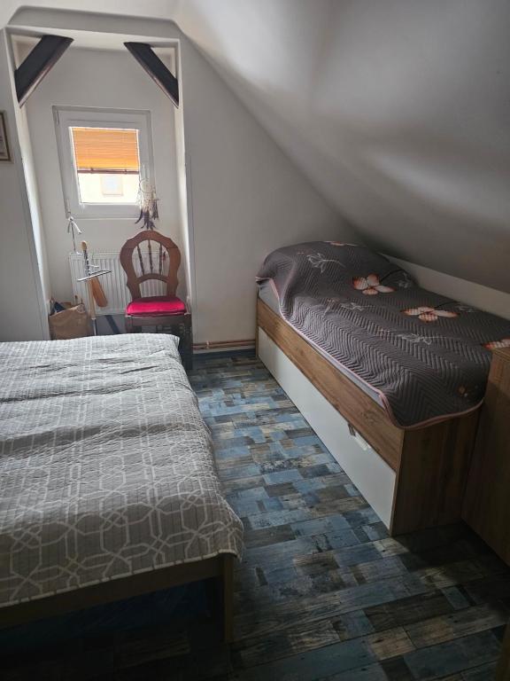 a small bedroom with two beds and a chair at Ubytování Rumberk 2 in Deštná