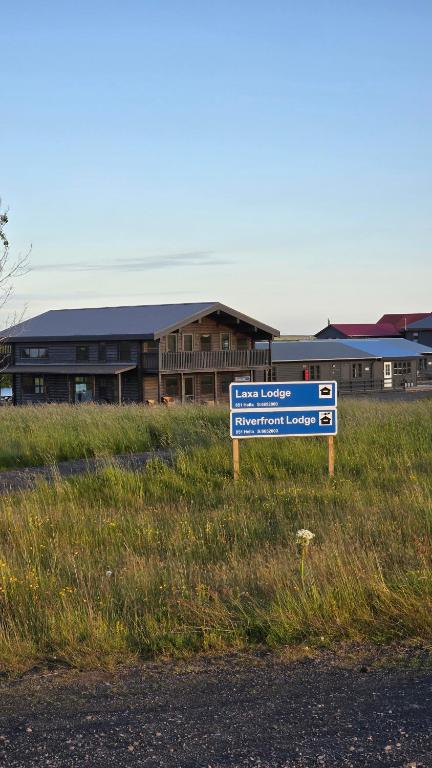 a blue sign in the grass in front of a building at Riverfront Lodge Hella in Hella