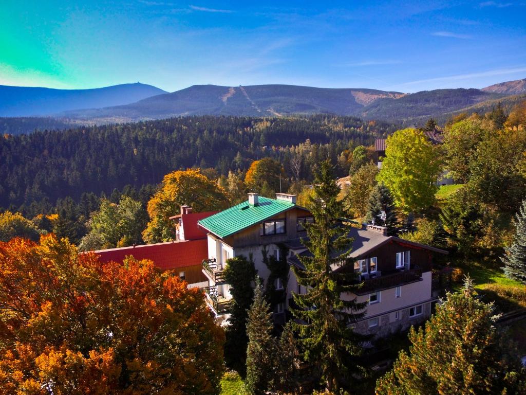 a house with a green roof with mountains in the background at Cichy Kącik w Karpaczu in Karpacz