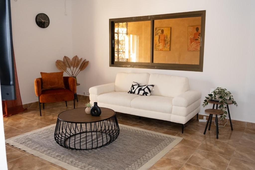 a living room with a white couch and a table at T3 Elegance x Nawassi Moderne, climatisé, sécure in Pamandzi