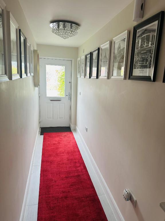 a hallway with a red carpet and a white door at GR8 Home in Kingsley