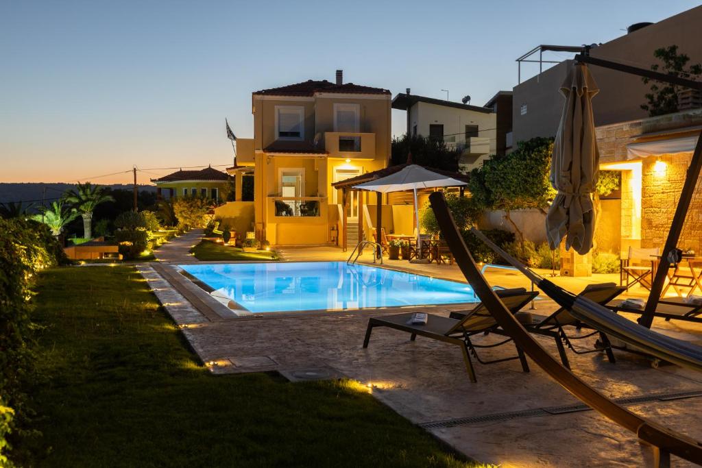 a villa with a swimming pool in front of a house at Chios Seafront Luxury Villa with Pool in Chios