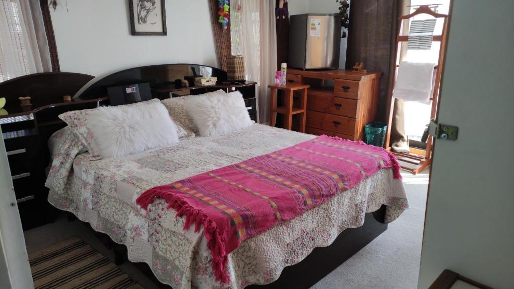 a bedroom with a bed with a pink blanket at KositasRikas B&B in Viña del Mar