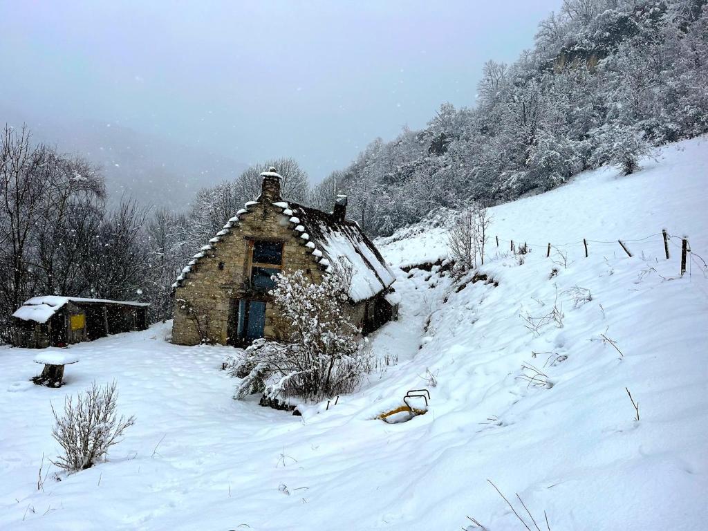 an old cabin in a snow covered field at La grange du Taillat in Campan