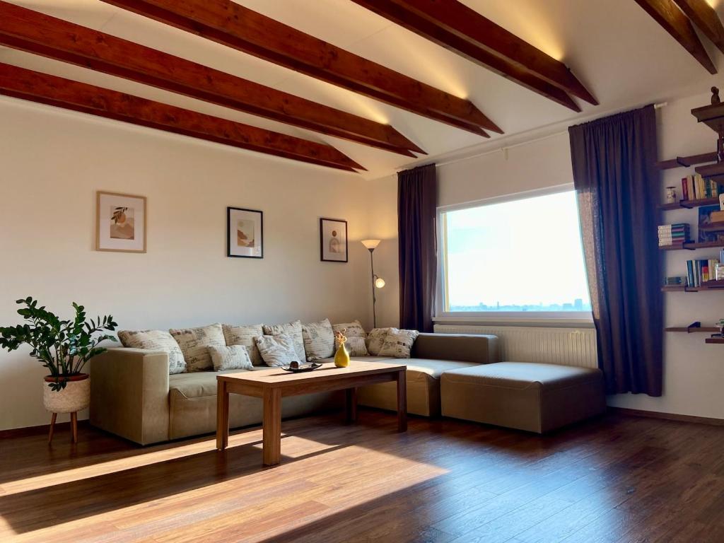 a living room with a couch and a table at Priestranný apartmán s veľkorysým výhľadom in Rača