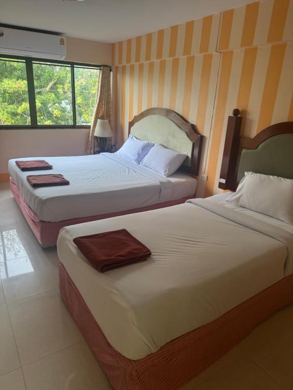 two beds in a hotel room with two beds sidx sidx at Skippers beach guesthouse in Hua Hin