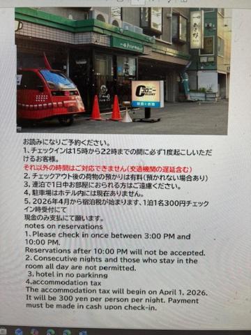 a sign with a car parked in front of a store at Asano Hotel in Sapporo