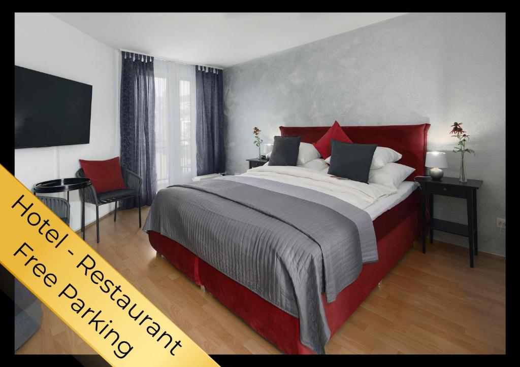 a bedroom with a large bed with red pillows at Hotel Restaurant Egerkingen, idealer Zwischenstopp in Egerkingen