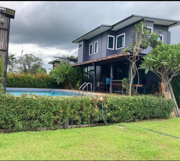 a house with a swimming pool in front of it at บ้านฮิมฝั่งแกนพูลวิลล่า in Ban Pong (2)