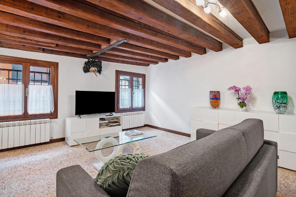 a living room with a couch and a tv at Ca' Della Torre, a 5 min da Rialto in Venice