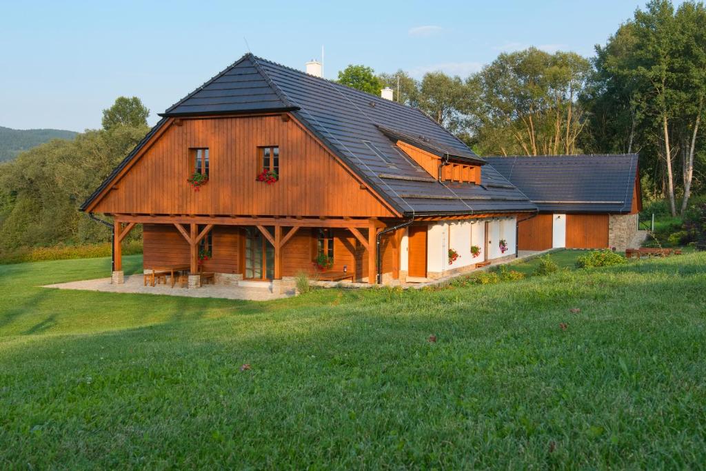 a large wooden house with a black roof at Chalupa Pod Šerovnou in Prachatice
