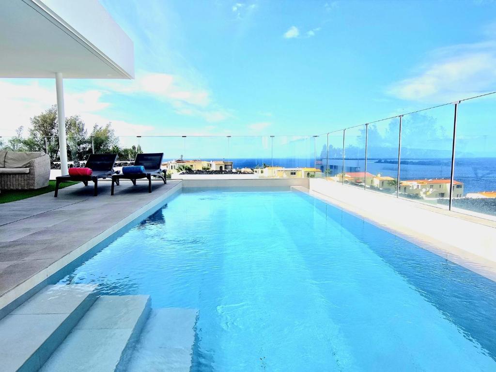 a swimming pool in a house with a view of the ocean at AUX VILLAS DE MICK in Callao Salvaje
