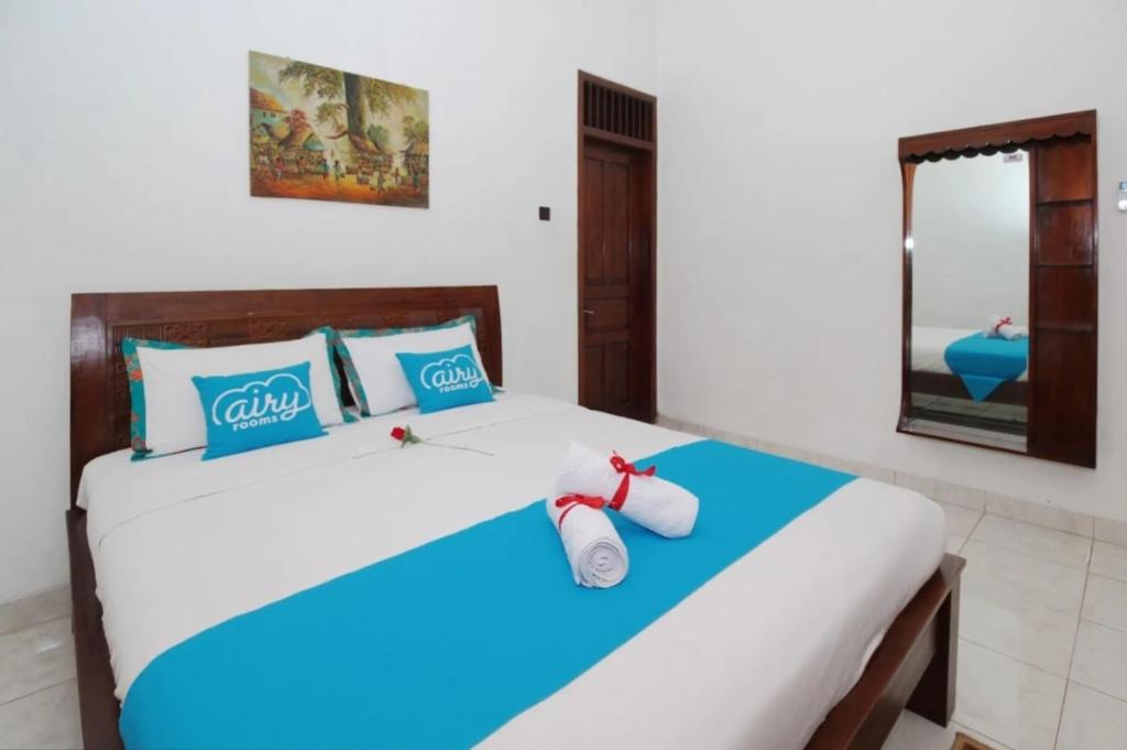 a bedroom with a bed with blue and white at Guest House Pogung Baru in Yogyakarta
