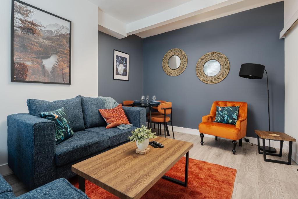 a living room with a blue couch and a table at Cosy Anfield Home in Liverpool