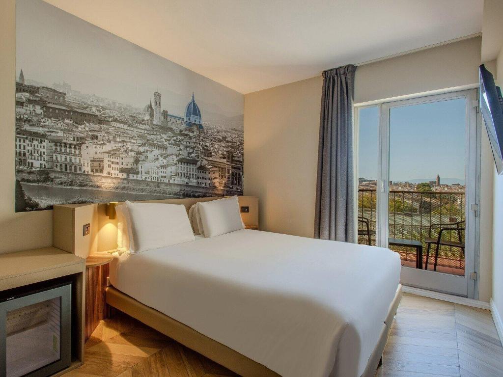 a hotel room with a bed and a large window at B&B Hotel Firenze City Center in Florence