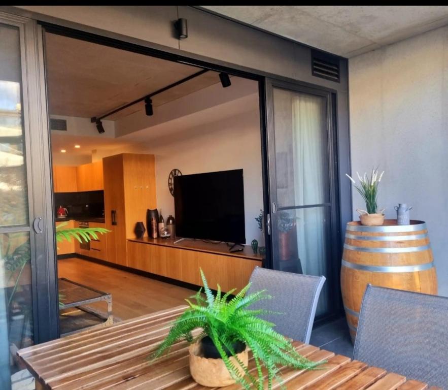 a living room with a table and a tv and a room with a barrel at Bliss in Braddon in Braddon