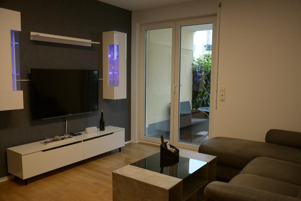 a living room with a couch and a flat screen tv at Exklusive Wohnung mit Garten in Niederdorla