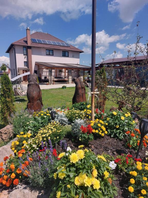 a garden of flowers in front of a house at Sári Vendégház in Remetea
