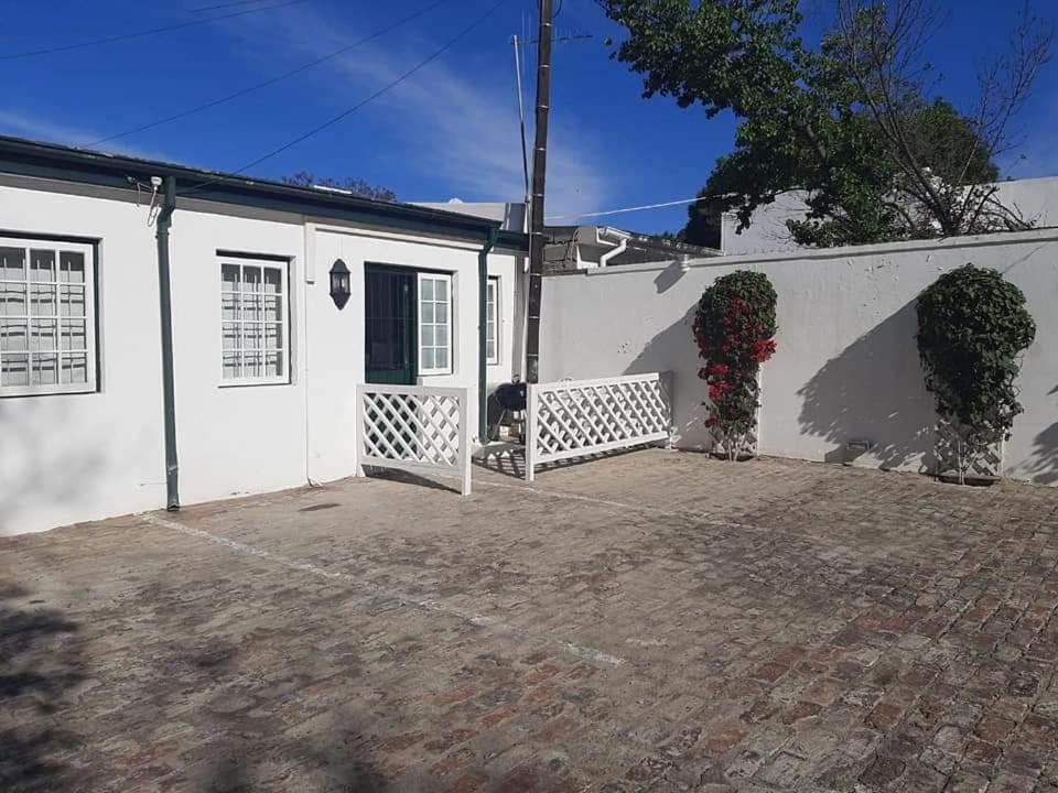 a white house with a driveway in front of it at De Kothuize 4 in Graaff-Reinet