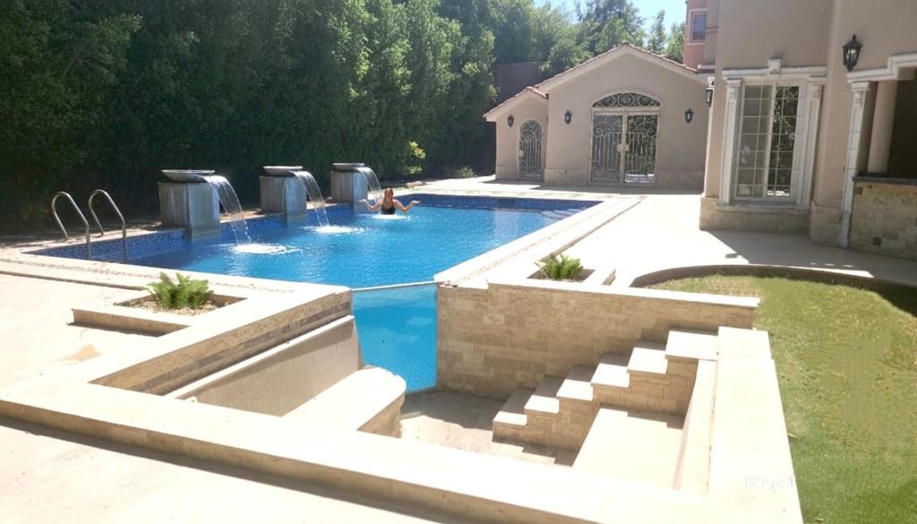 a swimming pool in the backyard of a house at Evermond Suites in Alexandria