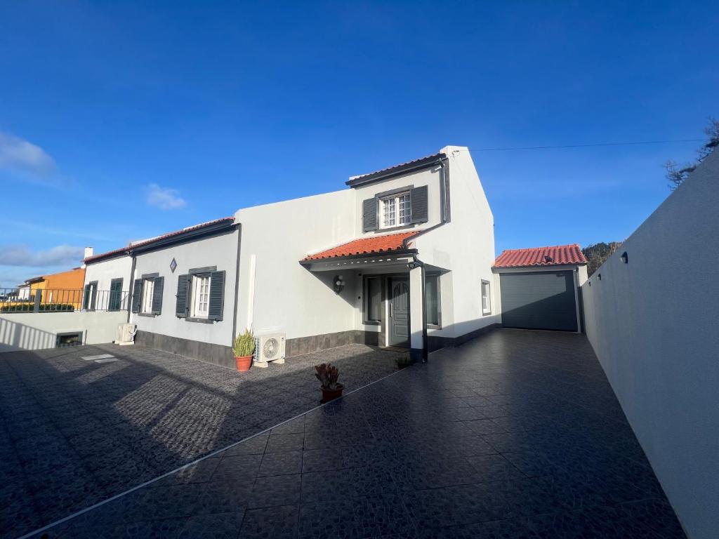 a large white house with a driveway at A Casa do Navio in Capelas