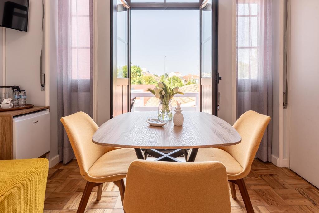 a dining room with a table and chairs and a window at Magnolia Inn in Aveiro