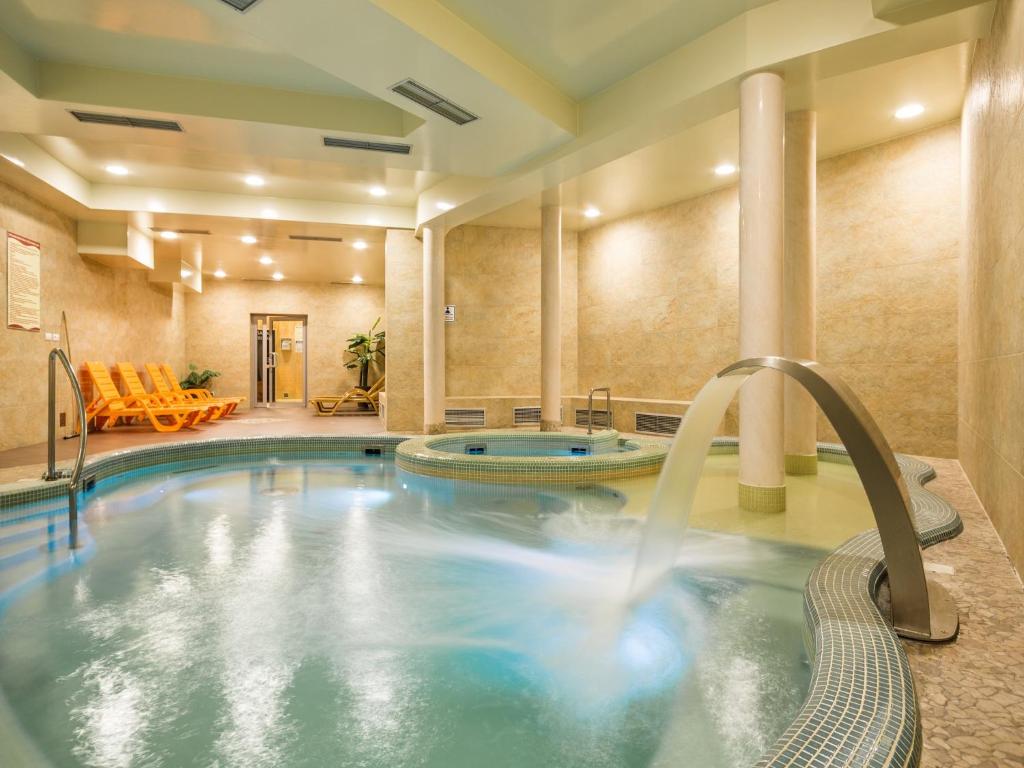 una piscina en una habitación de hotel con bañera de hidromasaje en TatryTop Gorące Źródła Spa en Zakopane
